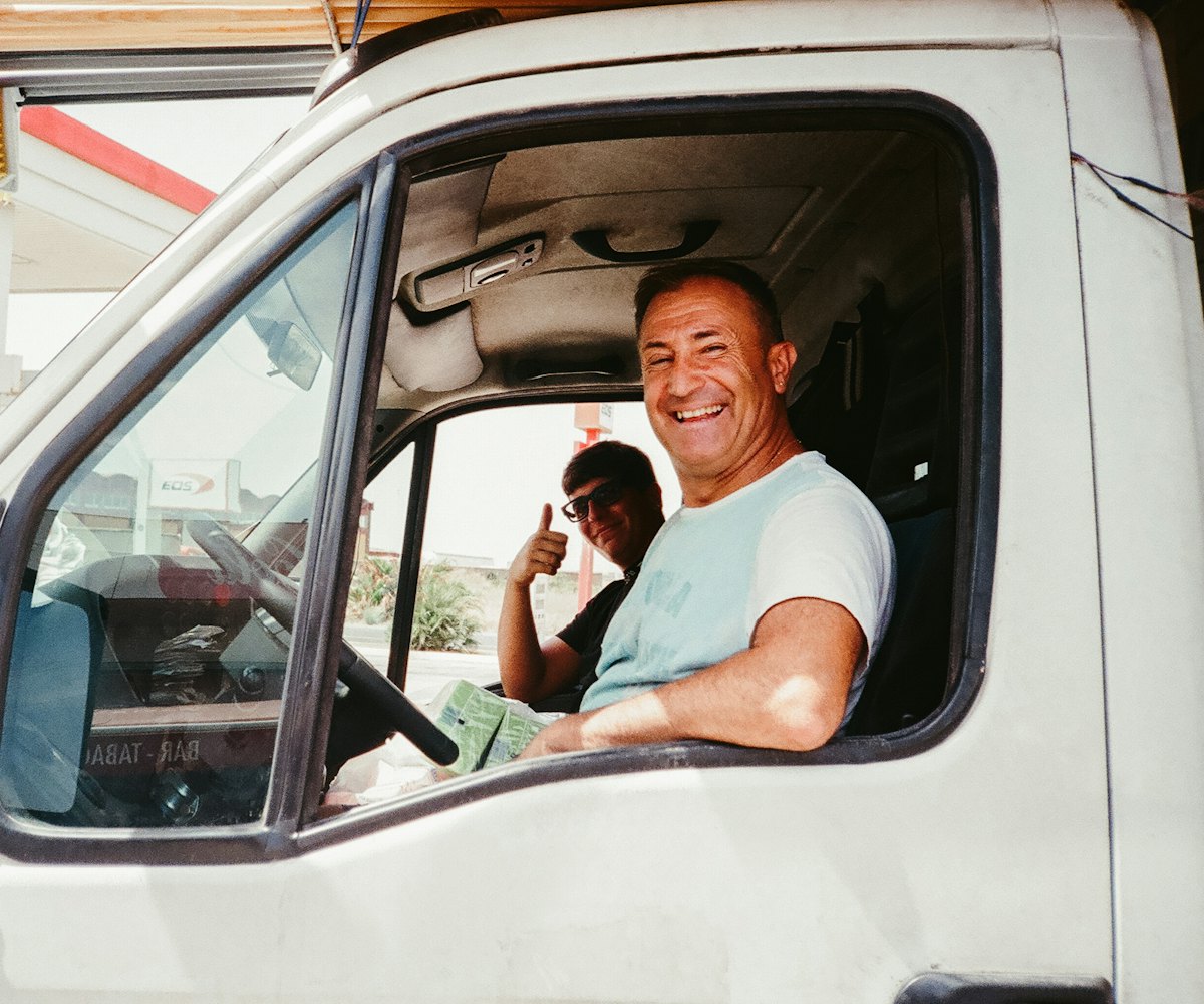 Un chauffeur souriant dans sa camionnette