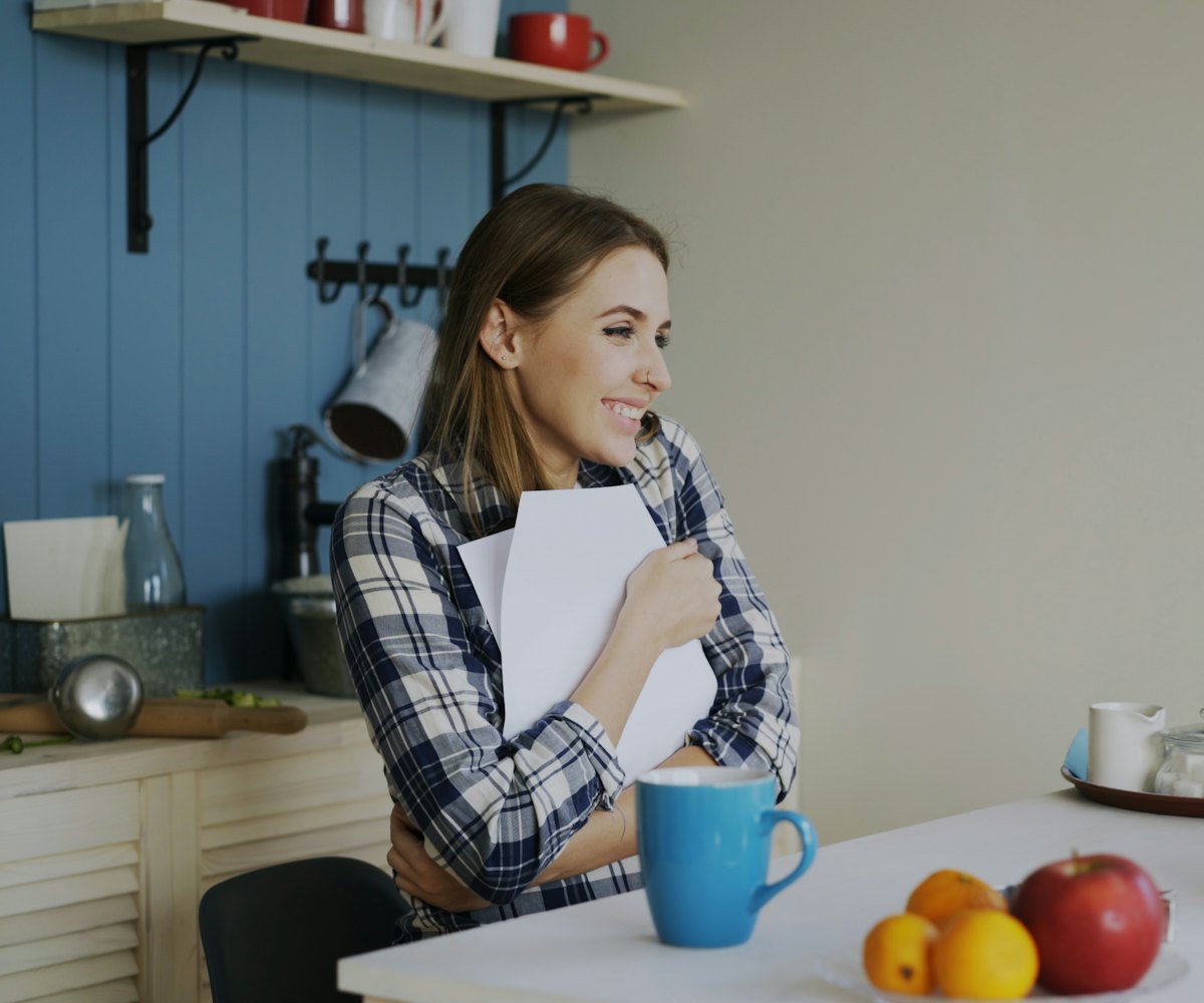 Femme souriante à la table de sa cuisine